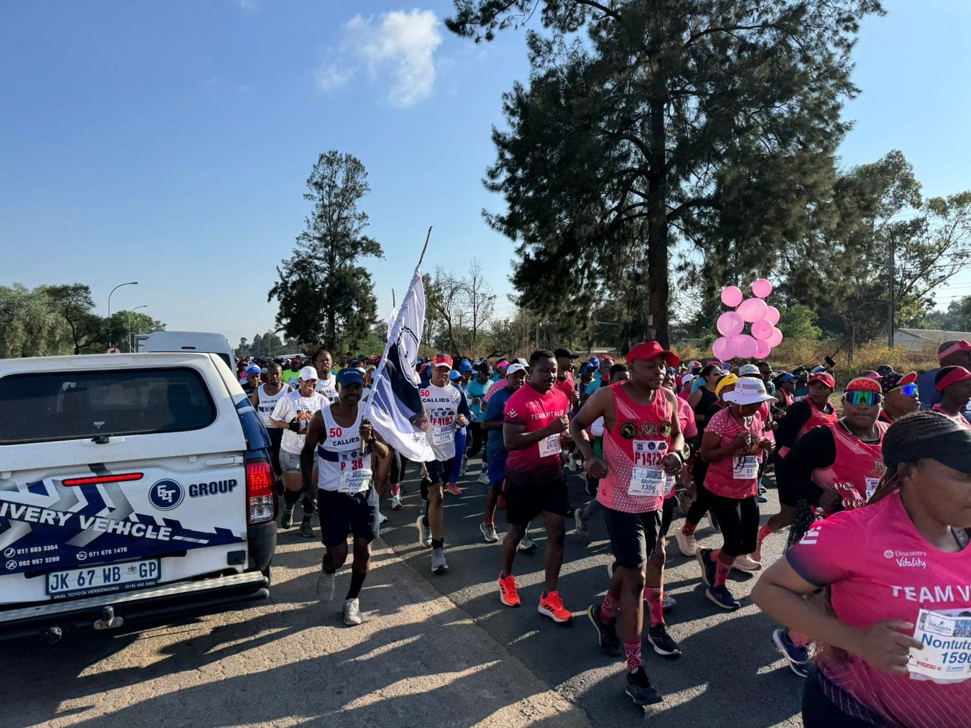 Germiston Callies runners carrying the club flag at a road race